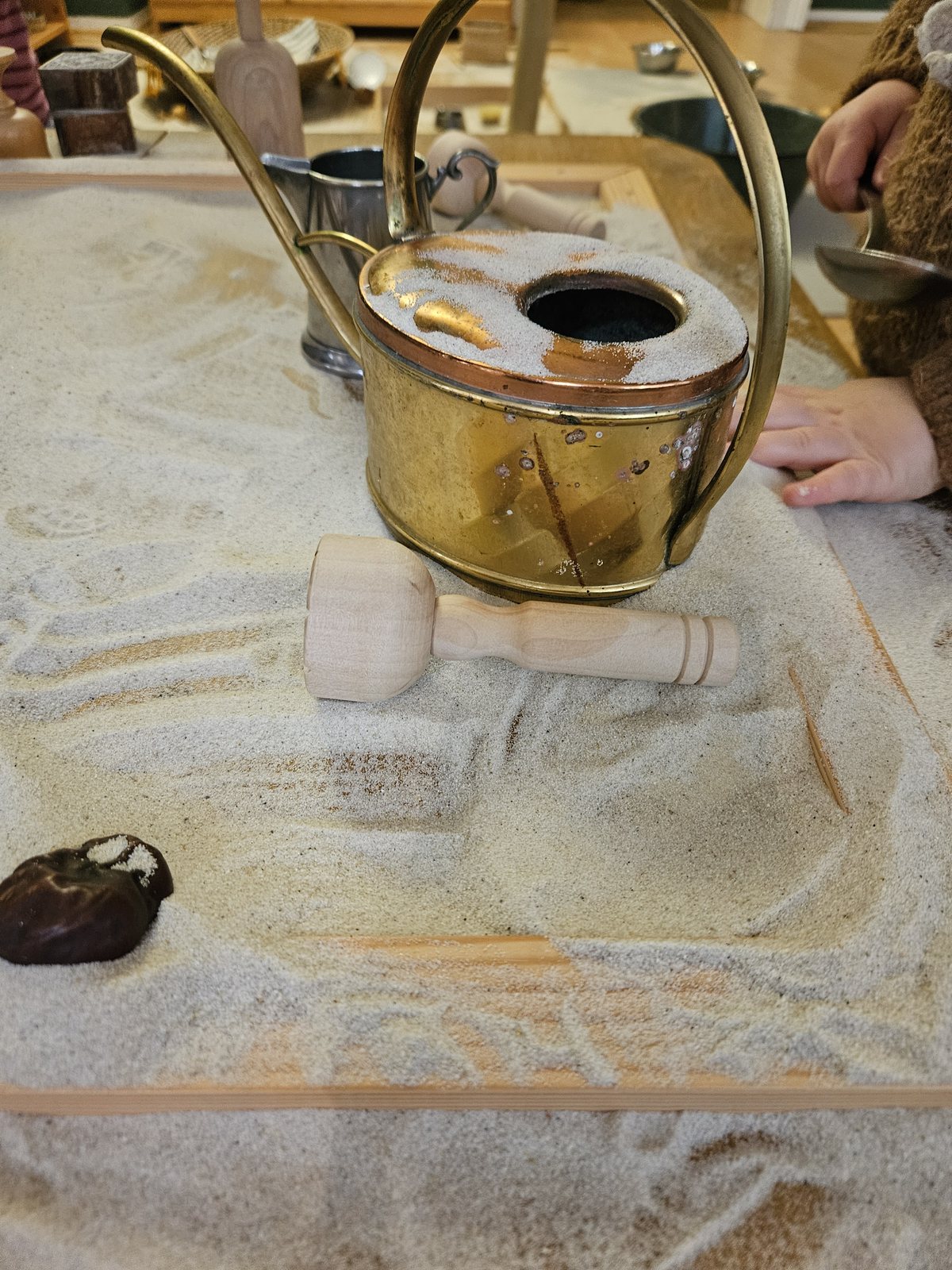 Messing-Gießkanne auf dem Sandtisch